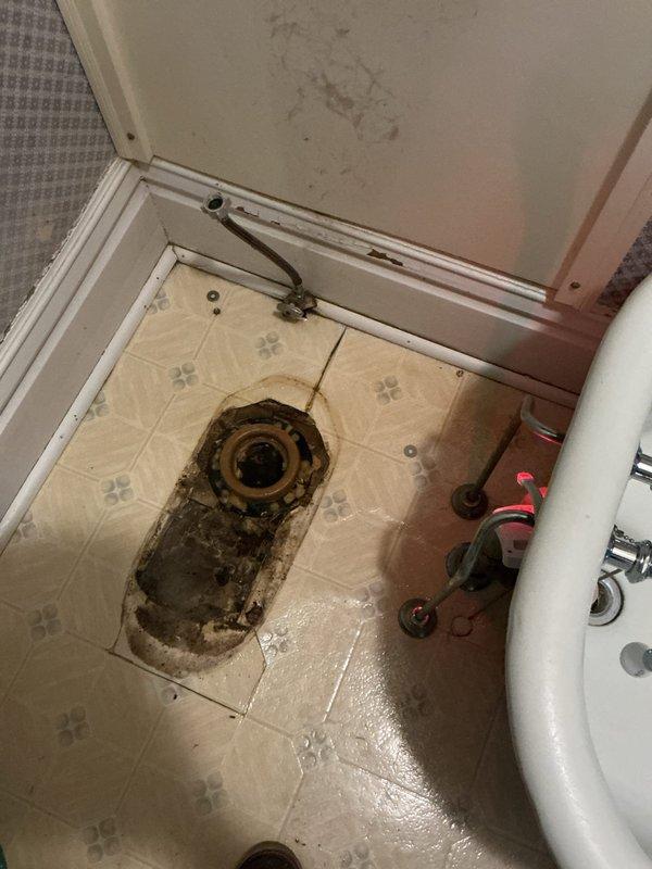 Completed replacement of deteriorated toilet, addressing significant water damage around the floor drain. Identified and rectified leaking compression nut on stop valve by replacing the toilet fixture and properly tightening the supply line connection to ensure proper water flow and prevent future leakage.