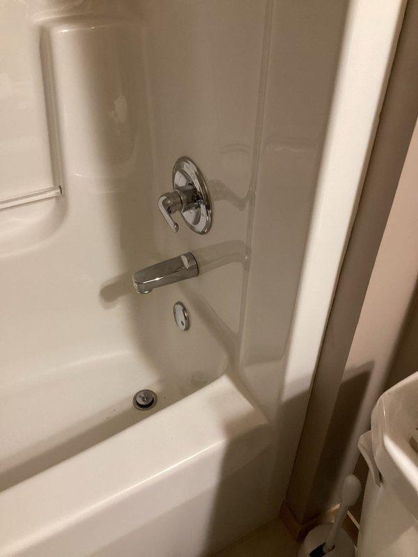 Conducted comprehensive plumbing inspection of residential property, examining bathroom shower/tub installation with chrome fixtures and diverter spout in good working condition. Basement inspection revealed properly installed sump pump system with PVC and metal piping connections, functioning valve, and appropriate drainage setup with no visible leaks or operational issues detected.