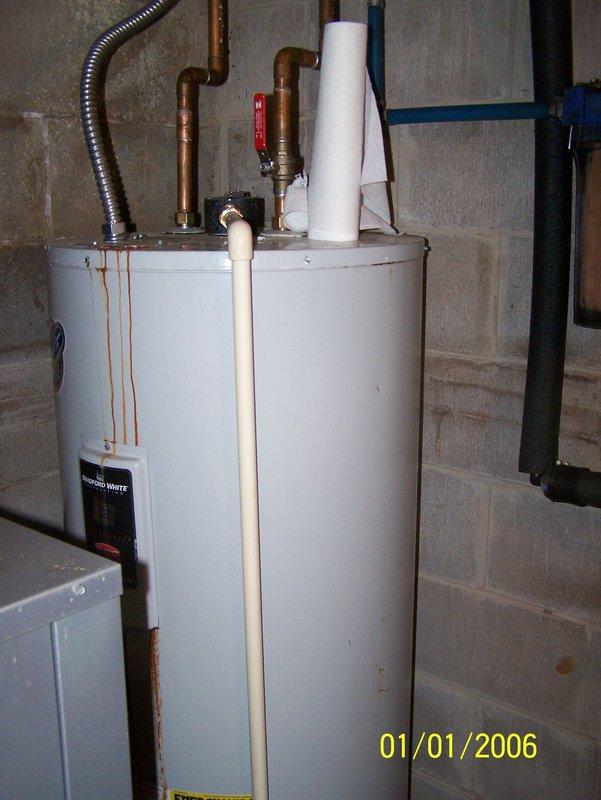 Responded to service call for water heater leaking from top connections. Diagnosed significant corrosion and rust streaking down tank side originating from upper fittings. Removed failed 50-gallon electric water heater and installed new replacement unit with proper connections to existing plumbing system.