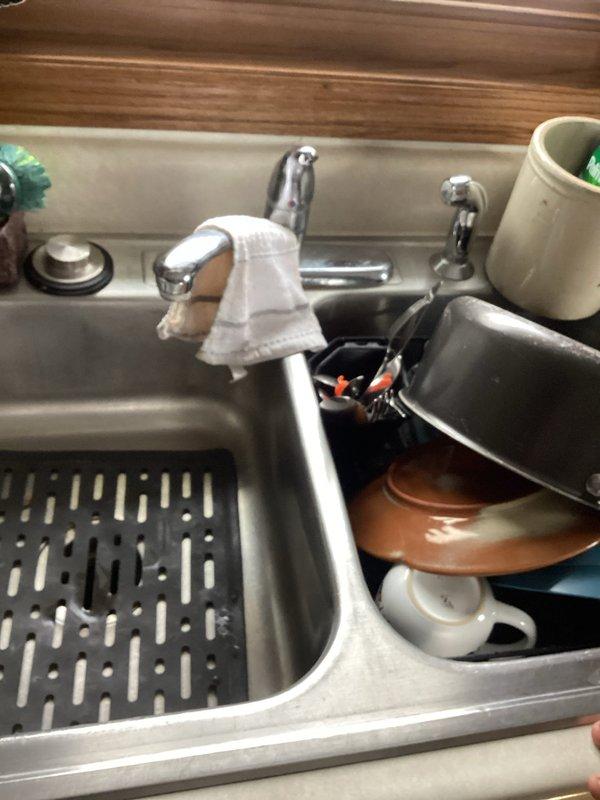 Completed plumbing inspection for family connection. Inspected newly remodeled bathroom and kitchen fixtures, noting proper installation of bathroom sink with matte black faucet and kitchen double basin with chrome fixtures. Identified and documented missing valve on exterior lawn faucet requiring attention.