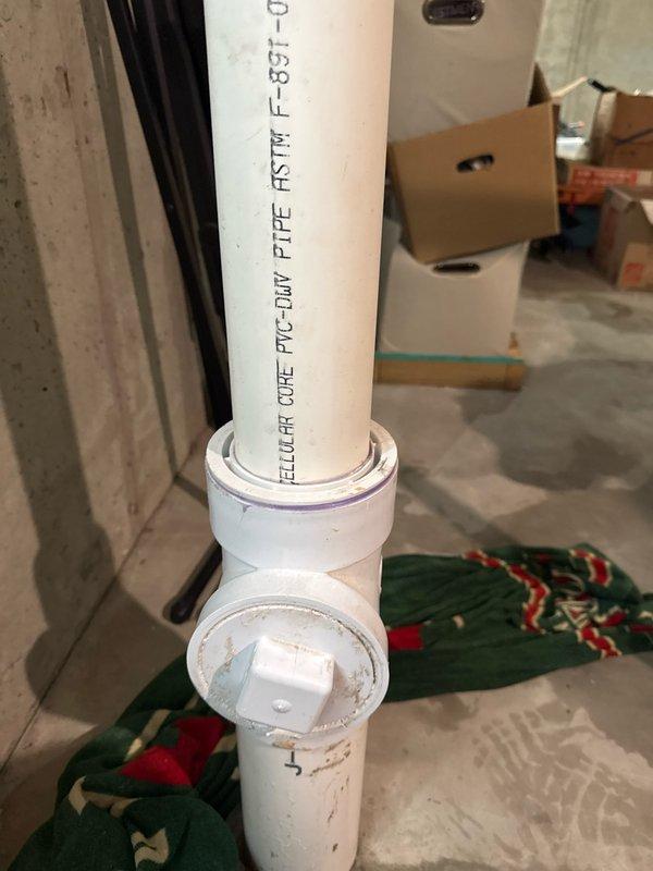 Diagnosed and inspected a reported leak from the square plug area of a T-shaped fitting on a PVC-DWV pipe in the basement. Visual examination confirmed a cracked tee junction, which was also contributing to a sewer backup issue. Referred customer to drain specialists for the backup problem.