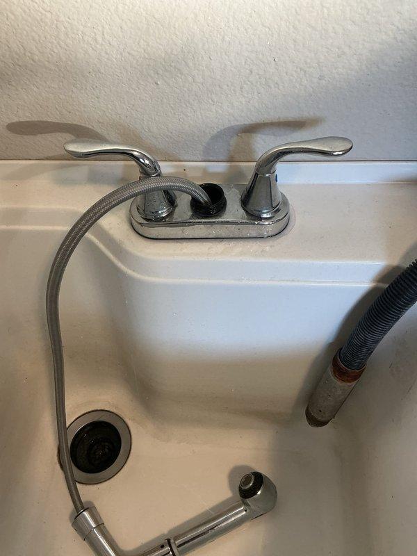 Diagnosed and identified two separate leaks: a cracked pivot rod assembly causing water leak beneath bathroom sink and a faulty hose attachment under laundry sink. Provided customer with repair estimates for both issues, noting that hard water conditions are likely contributing to multiple faucet failures throughout the home. Customer will decide on proceeding with recommended repairs after consultation with spouse.