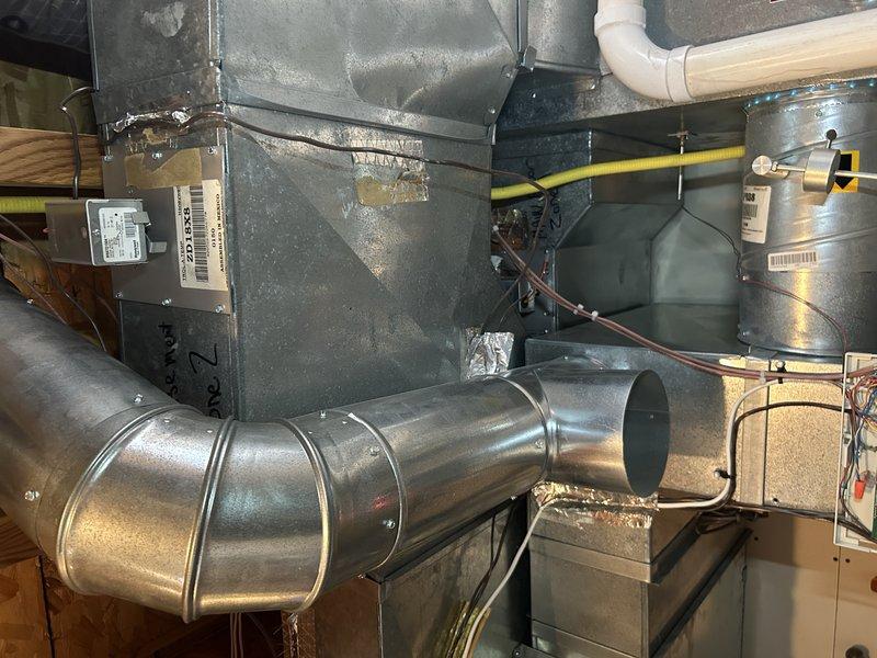 Diagnosed whistling and banging noises originating from a binding zone damper for the main floor that is not opening properly when activated. Determined that replacement of the problematic damper requires significant ductwork removal due to its location behind existing ductwork. Recommended replacement of both zone dampers as a preventative measure since they are of the same age.