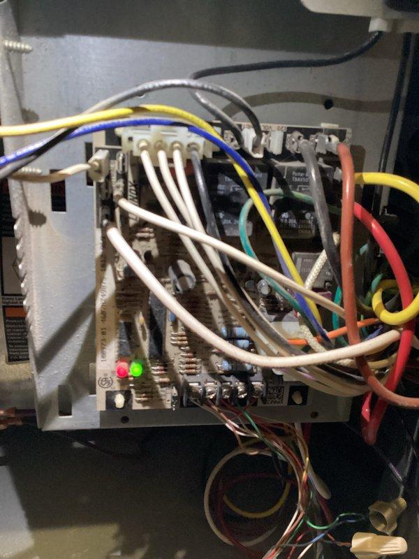Diagnosed 15-year-old natural gas furnace with intermittent operation issue where thermostat was not triggering furnace activation during temperature drops. Inspection of control board revealed voltage drop to inducer motor, preventing proper startup sequence. Documented condition of control board connections and overall system installation for service advisor recommendation.