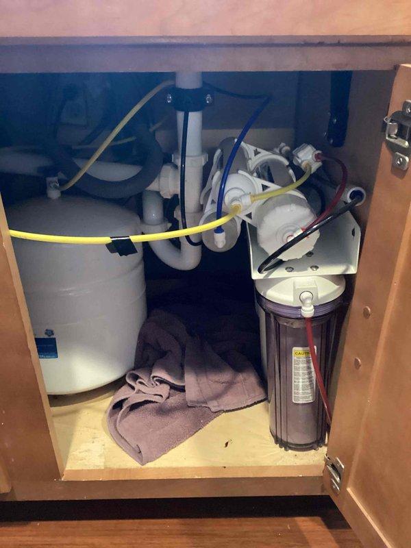 Successfully installed customer-supplied kitchen faucet with pull-down sprayer feature on granite/quartz countertop. Replaced reverse osmosis filtration system with customer-supplied components, ensuring proper connection of all colored tubes to the transparent filter housing and pressurized tank. Repaired hot water line in downstairs bathroom to restore proper functionality.