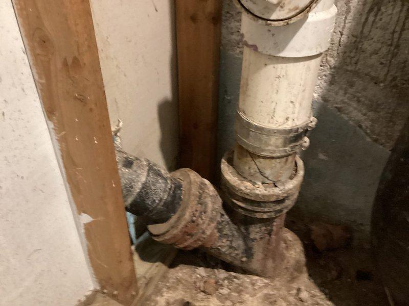 Completed measurement and preparation work for sewer liner installation. Accessed existing plumbing system, cut sections as required, and took final measurements to ensure proper liner specifications. Photos documented the current system configuration including expansion tank mounting and PVC pipe connections prior to liner installation.