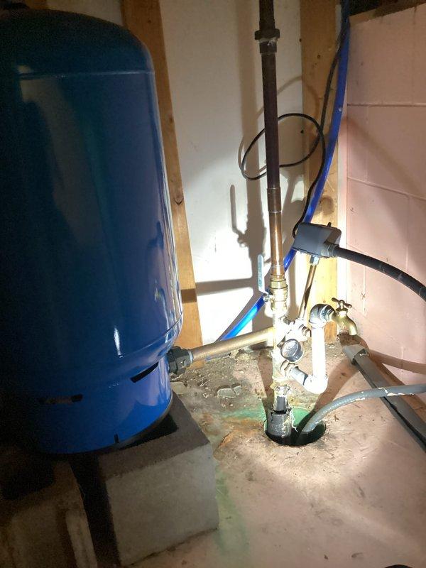 Completed plumbing inspection of residential water system. Inspected pressure tank installation with associated valves and PVC connections. Noted significant sediment/mineral buildup in toilet tank with discolored water, indicating potential water quality issues that may require further attention.