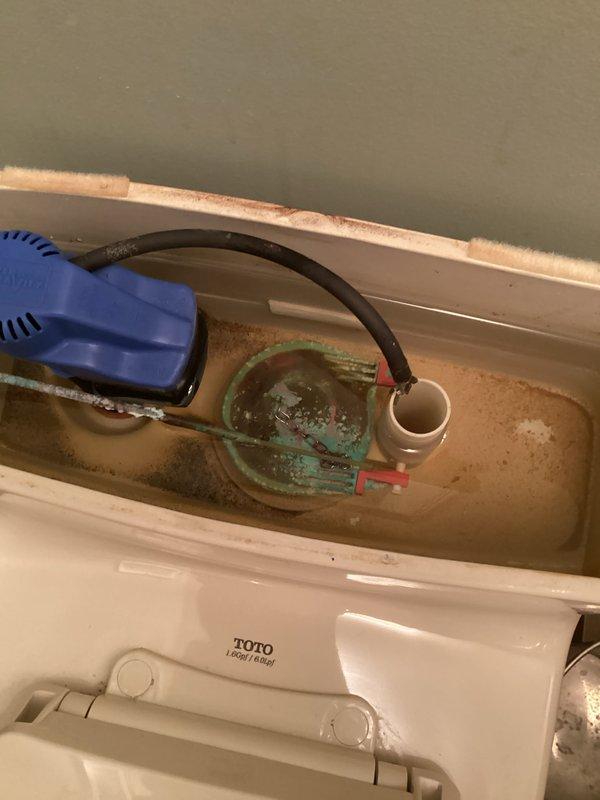 Conducted comprehensive plumbing inspection of bathroom fixtures, focusing on TOTO toilet and sink installation. Observed significant mineral buildup and staining in toilet tank components including float mechanism and flushing system. Sink examination revealed functional brushed nickel faucet with dual handles; minor staining noted around drain area.