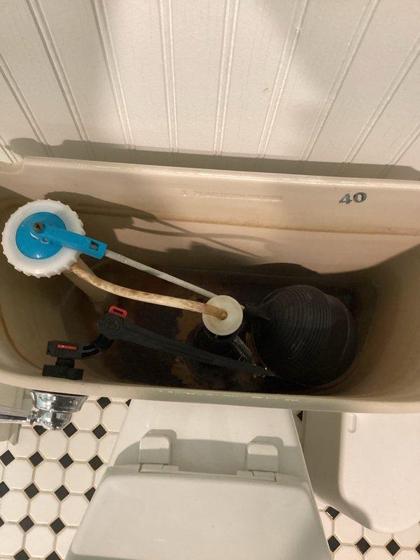 Conducted comprehensive plumbing inspection of residential property, examining toilet flush mechanism components which showed normal wear but appeared functional. Inspected water softener system and associated plumbing connections in basement area, noting proper installation with no visible leaks, while also observing adjacent dehumidifier setup with drainage hose.