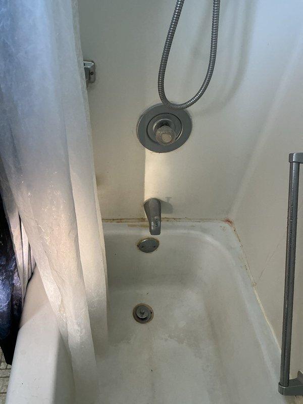 Conducted comprehensive plumbing inspection per annual service agreement. Identified defective water heater with melted top thermostat and replaced with new 50-gallon electric unit. Also documented toilet tank with mineral buildup and bathtub with significant rust staining around drain area, which may require future attention.