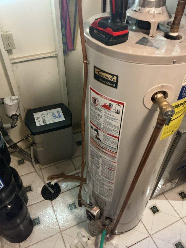 # Service Report: Water Heater Replacement

Successfully completed installation of a new 40-gallon residential water heater in utility room. Removed existing water heater and installed replacement unit, connecting all copper supply lines with brass fittings and ensuring proper integration with existing plumbing infrastructure including water softener system. All connections were secured with appropriate shutoff valves, pressure relief valve was properly installed, and unit was tested for proper operation and leak-free performance upon completion.