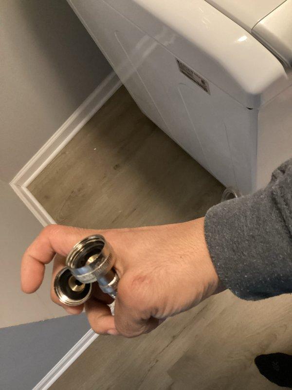 Responded to water leak affecting lower level ceiling caused by washing machine supply line connection. Upon inspection, identified failed rubber gasket at hose connection point where supply line enters wall-mounted utility box. Shut off water supply valves, disconnected affected washer hose, and replaced deteriorated gasket with new component. Reconnected supply line, verified proper seal at all connection points, restored water supply, and tested system under pressure to confirm leak was eliminated. No further water intrusion observed.