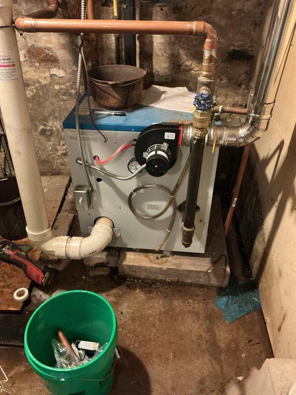 Responded to emergency call for well system leak with water gushing from plumbing connections leading to pressure tank. Upon inspection, identified failed factory-soldered joints on tank tee fitting between well and pressure tank. Removed defective tank tee assembly and installed new tank tee with all necessary components including isolation valves, pressure switch, and pressure gauge to restore proper well system operation and eliminate active leak.