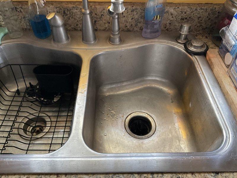 Responded to service call for leaking garbage disposal that had reportedly fallen off, preventing dishwasher use. Upon inspection, determined that the locking ring on the 3/4HP InSinkErator disposal unit had come loose, causing the leak and instability. Tightened the locking ring to the locked position using the manufacturer's included tool, securing the disposal properly to the sink mounting assembly. Verified unit was stable and leak-free after repair. No replacement was necessary.
