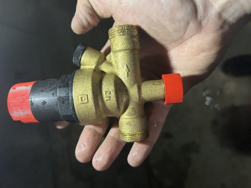 Responded to no heat call on boiler system displaying low water tank error code. Upon inspection, discovered the boiler was critically low on water and the auto-fill system was not functioning. Diagnosed the issue to a failed backflow preventer blocking water flow to the boiler. Disconnected the backflow preventer from the auto-fill assembly and opened the upstream valve, confirming no water flow through the device. Attempted to free the stuck internal components of the backflow preventer without success. Manually filled the boiler system to restore temporary operation and bring system pressure to safe operating levels. Backflow preventer requires replacement to restore automatic water feed functionality and prevent future low water conditions.