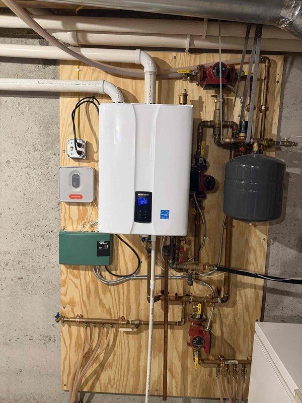 Responded to service call for a Navien NPB-240 natural gas boiler system located in the basement. Upon inspection, discovered a faulty heat exchanger and completely melted sight glass, both requiring immediate replacement for safe operation. Replaced the defective heat exchanger, ignitor/flame sensor assembly, and sight glass with OEM parts. Additionally performed comprehensive maintenance tune-up on the 18-year-old gas forced air furnace system, including inspection of all critical components, burner cleaning, and safety checks. Following repairs, conducted full operational testing of the boiler system to verify proper ignition, flame sensing, combustion efficiency, and heat output. All systems tested and confirmed to be operating within manufacturer specifications. Unit returned to safe and efficient service.