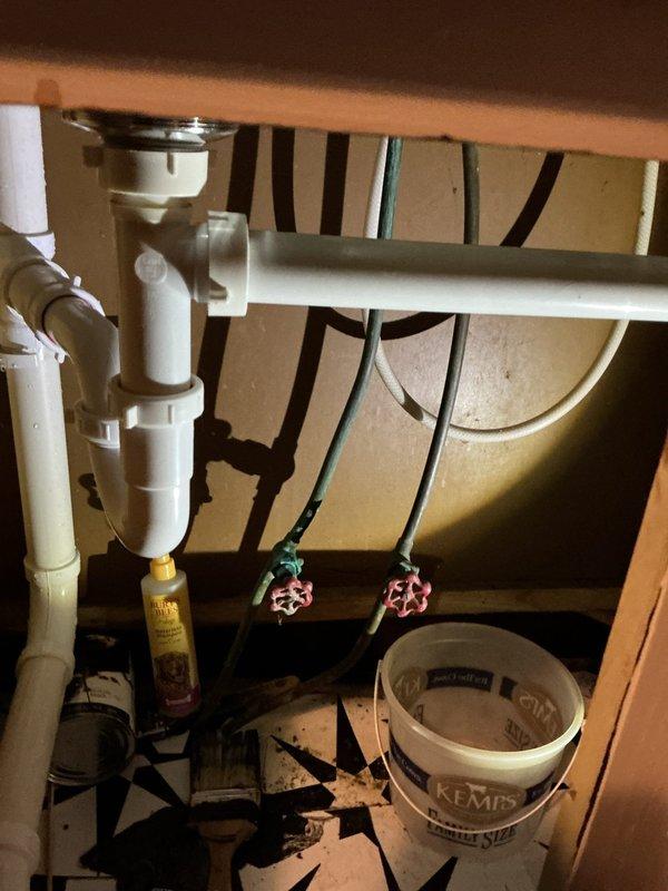 Responded to kitchen sink leak occurring only during dishwashing. Upon inspection, identified deteriorated spray hose on existing kitchen faucet assembly causing water to spray underneath sink cabinet during use. Removed old single-handle chrome faucet with deteriorating spray attachment from stainless steel double-basin sink. Installed new single-handle kitchen faucet with separate side spray assembly. Tested all connections under load to verify proper operation and confirmed no leaks present during normal use and spray function activation.