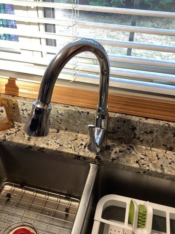 Completed comprehensive plumbing inspection of residential kitchen fixtures and under-sink plumbing system. Verified proper operation of chrome pull-down faucet, examined garbage disposal unit (model E202) with connected PVC drain lines and flexible supply lines, and confirmed all components were functioning correctly with no visible leaks or deficiencies noted.
