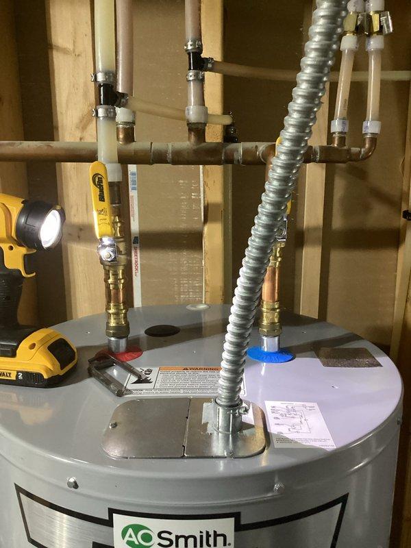 Responded to warranty service call for 50-gallon AO Smith electric water heater that was leaking at the base, having been installed in November 2024. Upon inspection, confirmed active leak from drain valve assembly with visible water accumulation on concrete floor requiring towel placement for moisture control. Documented defective unit with photographs showing plumbing connections, PVC and copper piping configuration, and leak source at brass drain valve. Coordinated warranty replacement with manufacturer, as equipment remains under warranty coverage while labor is customer responsibility. Provided estimate for warranty replacement installation and arranged scheduling for new unit delivery and swap-out service.