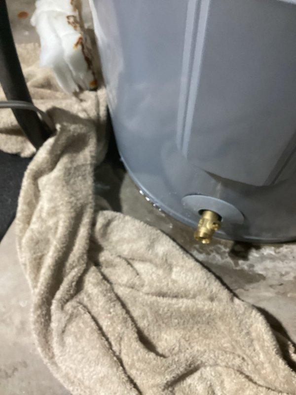 Responded to warranty service call for 50-gallon AO Smith electric water heater that was leaking at the base, having been installed in November 2024. Upon inspection, confirmed active leak from drain valve assembly with visible water accumulation on concrete floor requiring towel placement for moisture control. Documented defective unit with photographs showing plumbing connections, PVC and copper piping configuration, and leak source at brass drain valve. Coordinated warranty replacement with manufacturer, as equipment remains under warranty coverage while labor is customer responsibility. Provided estimate for warranty replacement installation and arranged scheduling for new unit delivery and swap-out service.