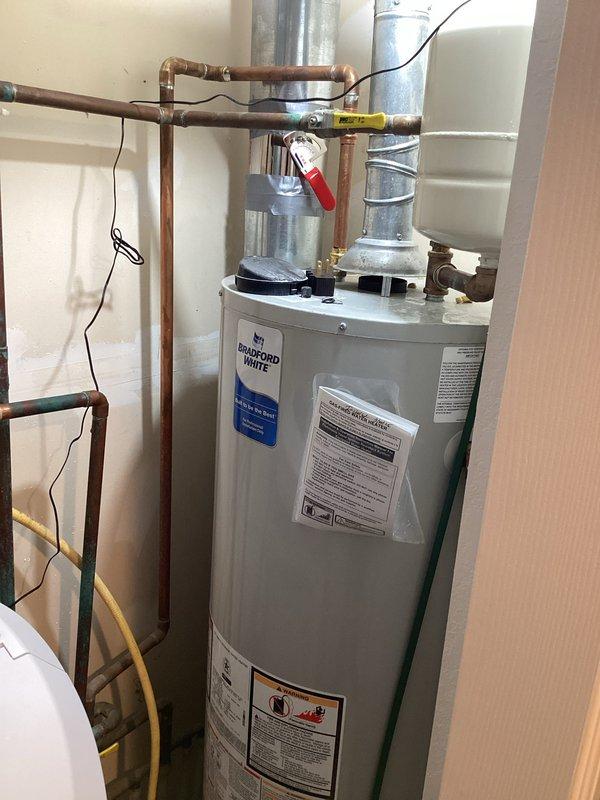 Completed comprehensive plumbing inspection of residential property including laundry area and water heater installation. Inspected washing machine water supply connections, shut-off valves, and flexible hoses in laundry room; verified Bradford White water heater installation with copper piping configuration, ball valve operation, and proper venting system. All plumbing components, connections, and fixtures were documented photographically and found to be in serviceable condition.