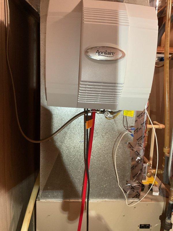 Performed comprehensive AC tune-up on system that had not been serviced in 4-5 years with no reported issues. Inspected all HVAC equipment including air conditioning unit, furnace, water heater, and Aprilaire humidifier, noting that all major equipment dates from 2004 and is nearing end of service life. Water heater shows significant deterioration and age-related wear, with visible corrosion and outdated plumbing connections requiring immediate attention for safety concerns. Discussed recommendations for replacing aging water heater and furnace due to equipment age and condition, as well as electrical panel upgrade needs to accommodate 220V sauna circuit with current 200-amp service at capacity. System operational at time of departure with advisement provided regarding prioritizing equipment replacements.