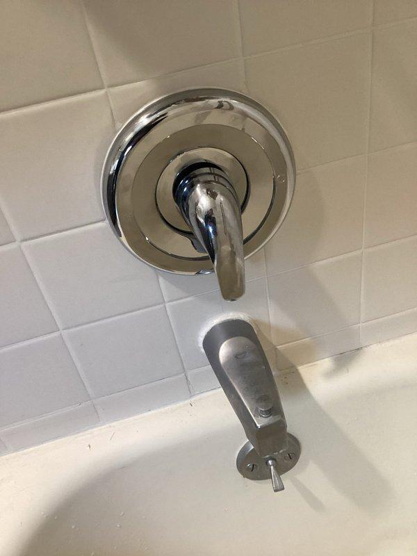 Completed shower trim kit replacement on existing bathtub/shower valve assembly. Removed old broken faucet handle and faceplate. Installed new chrome-finished single-lever handle with circular escutcheon plate and matching trim components. Verified proper operation of diverter mechanism and tested for leaks. All fixtures secured to white subway tile wall with proper sealing. System functioning correctly upon completion.