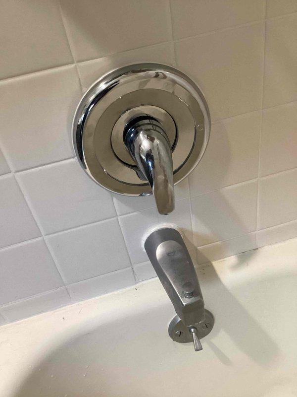 Completed shower trim kit replacement on existing bathtub/shower valve assembly. Removed old broken faucet handle and faceplate. Installed new chrome-finished single-lever handle with circular escutcheon plate and matching trim components. Verified proper operation of diverter mechanism and tested for leaks. All fixtures secured to white subway tile wall with proper sealing. System functioning correctly upon completion.
