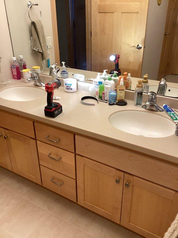 Completed comprehensive plumbing inspection of residential bathroom fixtures including double vanity sink configuration and toilet tank assembly. Inspected vanity plumbing connections, chrome faucets, undermount sinks, and toilet fill valve mechanism with float ball assembly, documenting conditions with photographs for service records.