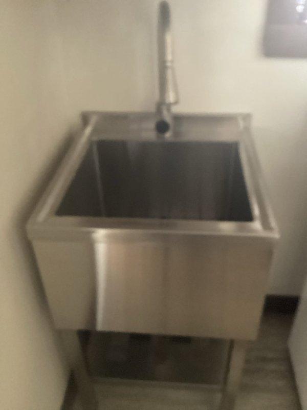 Completed installation of homeowner-supplied garbage disposal unit in kitchen. Successfully relocated utility sink from laundry room to basement area, including proper mounting of stainless steel commercial-style basin on metal legs and installation of chrome pull-down faucet with spray head functionality. All plumbing connections secured and tested for proper operation and drainage.