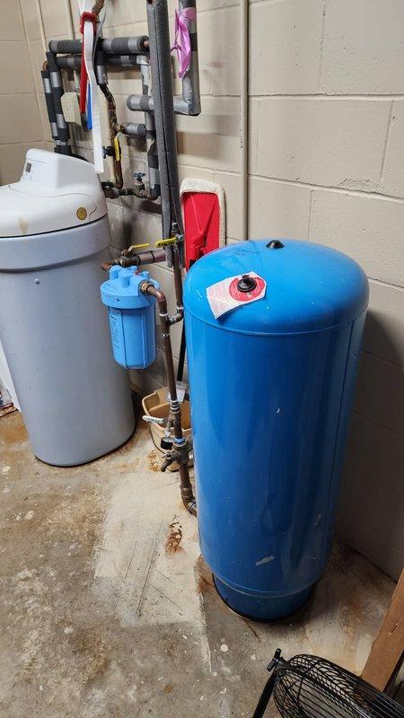 Responded to emergency water leak caused by burst 33-gallon expansion tank (Flexcon model PC122R) with failed bladder on main plumbing system. Water supply to residence was shut off upon arrival to prevent further damage.

Removed and replaced failed pressure tank with new Challenger brand expansion tank, including all necessary fittings and connections. Installed new effluent pump as requested. During system inspection, discovered malfunctioning water softener unit; removed softener from service and placed system on bypass to restore water flow.

Installed new Rusco whole house sediment filter system per homeowner request. Re-piped section of water supply lines adjacent to pressure tank location to accommodate removal of water softener unit and integration of new whole house filtration system. Reconfigured plumbing layout to ensure proper flow and access for future maintenance.

All new components tested and verified operational. System pressurized and checked for leaks. Water service