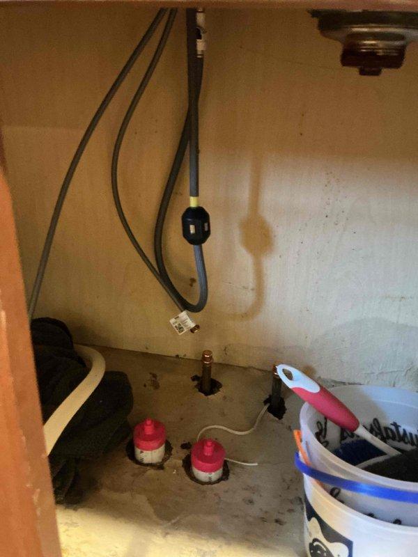 Disconnected water supply lines and drain plumbing for double-basin kitchen sink to facilitate countertop replacement. Shut off water valves beneath sink cabinet, removed P-trap and drain connections, and capped supply lines to prevent water damage during renovation. Return visit will be scheduled to reconnect all plumbing fixtures once new countertops are installed and kitchen island is repositioned.