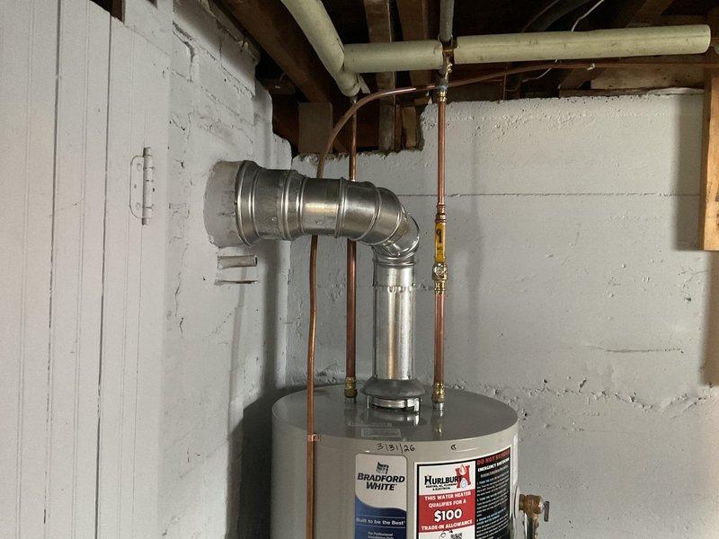 Responded to no hot water complaint at residential property. Removed failed existing water heater from basement utility area. Installed new Bradford White 40-gallon natural gas standard vent water heater in place of like unit. Connected copper supply lines with brass fittings to incoming cold water and outgoing hot water distribution. Installed metallic vent connector from unit draft hood to existing vent system. Verified all gas connections, tested for leaks, and confirmed proper combustion air supply. Restored hot water service to residence. Unit tested and operational upon completion.