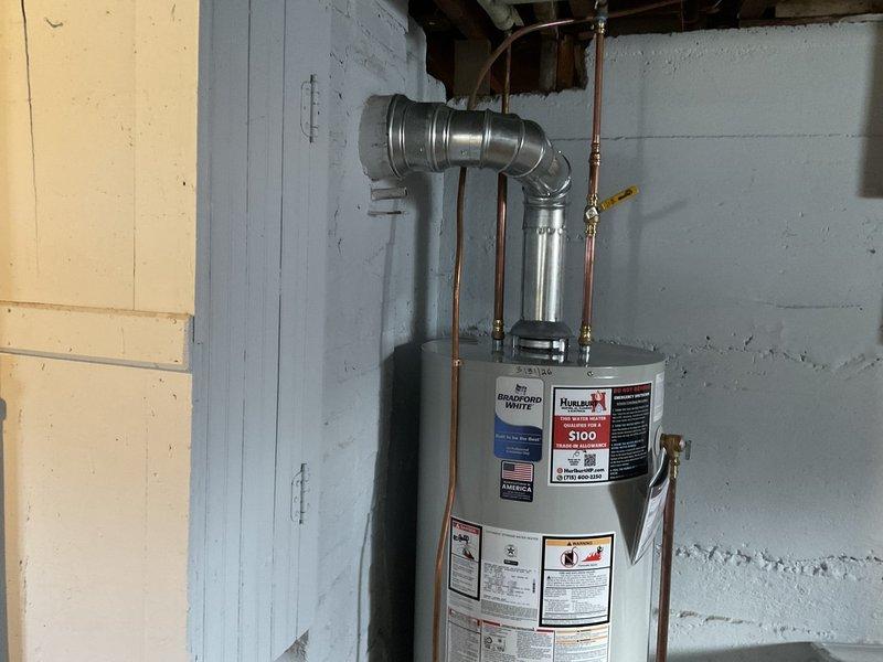 Responded to no hot water complaint at residential property. Removed failed existing water heater from basement utility area. Installed new Bradford White 40-gallon natural gas standard vent water heater in place of like unit. Connected copper supply lines with brass fittings to incoming cold water and outgoing hot water distribution. Installed metallic vent connector from unit draft hood to existing vent system. Verified all gas connections, tested for leaks, and confirmed proper combustion air supply. Restored hot water service to residence. Unit tested and operational upon completion.