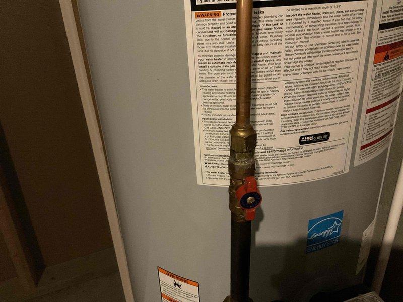 Completed comprehensive plumbing inspection of residential water heater and associated piping systems. Documented water heater condition, noting Energy Star rated unit in proper working order with all safety labels intact. Inspected copper supply lines, brass fittings, ball valves, and steel piping, observing normal condensation on fittings and minor age-related surface corrosion on lower pipe sections with no active leaks detected.