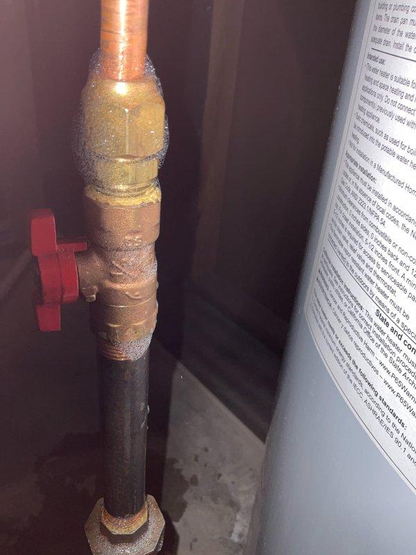 Completed comprehensive plumbing inspection of residential water heater and associated piping systems. Documented water heater condition, noting Energy Star rated unit in proper working order with all safety labels intact. Inspected copper supply lines, brass fittings, ball valves, and steel piping, observing normal condensation on fittings and minor age-related surface corrosion on lower pipe sections with no active leaks detected.