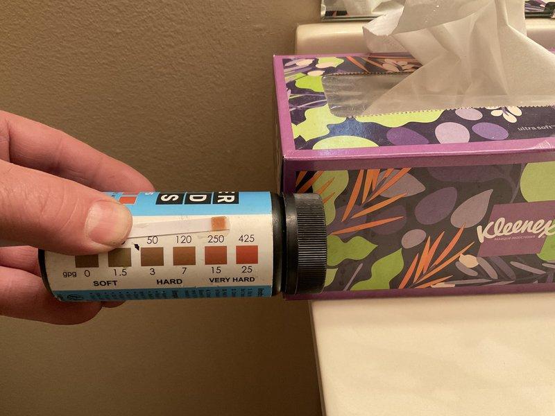 Completed comprehensive plumbing inspection identifying multiple issues requiring attention. Discovered active leak behind water heater requiring immediate repair to prevent water damage. Washing machine supply hoses showed signs of wear and deterioration, along with failed shock arrestors that need replacement to prevent water hammer and potential hose failure. 

Performed water quality testing using hardness test strips, revealing elevated mineral content in the water supply. Test results indicated hard to very hard water conditions, which can contribute to mineral buildup in plumbing fixtures and appliances, reducing their efficiency and lifespan.

Inspected toilet tank components and documented condition of internal mechanisms. Tank exhibited significant mineral deposits and water discoloration, consistent with hard water conditions. Flush valve assembly with rubber flapper, fill valve mechanism, and associated hardware showed age-related wear and mineral accumulation on tank surfa
