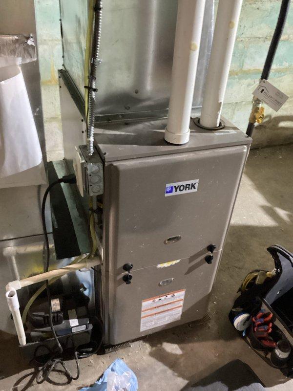 Responded to callback for York furnace experiencing short cycling and blowing cold air, same symptoms reported prior to recent limit switch replacement. Unit was operating normally upon arrival with no active fault codes. Performed diagnostic testing by manipulating wiring connections near rollout switches, which caused intermittent dropout and restart, indicating potential poor connection at left side rollout switch. Observed rust contamination on right side rollout switch from fresh air intake moisture. Tightened all electrical connections at both rollout switches, which resolved intermittent dropout during testing. Recommend replacing right side rollout switch due to corrosion and monitoring left side rollout switch for potential replacement. Control board remains possible contributing factor if symptoms persist. Advised customer to document any fault codes if unit malfunctions again to assist with further diagnosis.