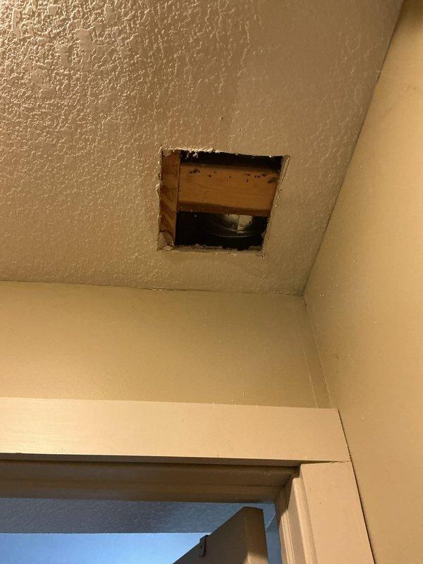 Responded to emergency water leak originating from upstairs bathroom causing active damage to main level ceiling. Upon arrival, main water supply had been shut off to prevent further damage. Investigation revealed cold water supply line serving kitchen had been compromised by rodent damage, resulting in hole in pipe and water discharge through ceiling. Created access points in kitchen cabinet and downstairs ceiling to expose damaged section of water line. Removed compromised pipe section and installed new piping using 90-degree elbow fitting and coupling to restore water supply line integrity. Restored main water supply and performed pressure test to verify repair and confirm no additional leaks present in affected area.