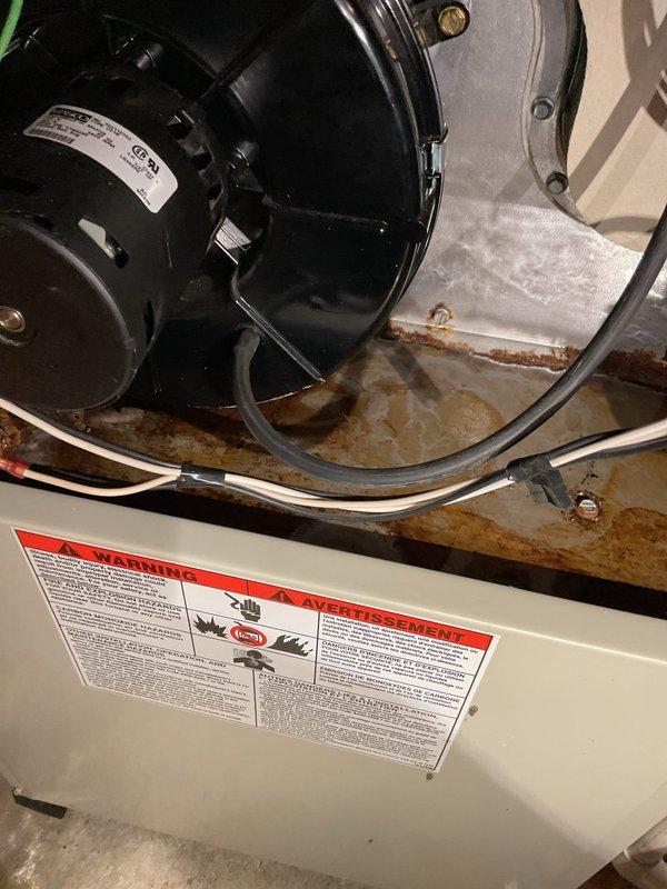 Responded to service call for water leaking in and around furnace. Upon inspection, identified failed seal between inducer motor and collector box, along with a compromised heat exchanger ring on deck causing water intrusion. Extensive rust and corrosion observed on furnace support framework and housing components, indicating prolonged moisture exposure. Documented equipment condition with photographs showing corroded metal surfaces, deteriorated seals, and water damage. Consulted with property contact on-site regarding findings and recommended furnace replacement due to heat exchanger failure and extent of water damage to critical components.