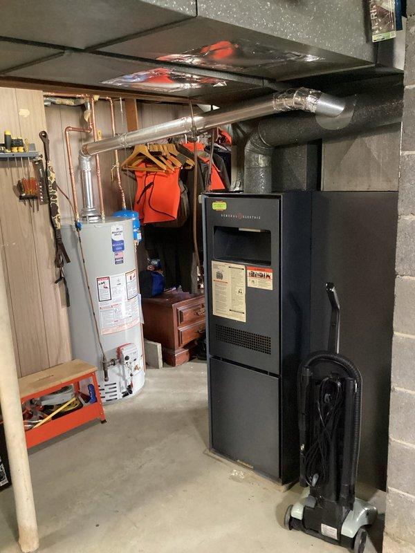 Performed comprehensive furnace tune-up on older General Electric unit. Replaced dirty air filter with customer-supplied unit. Inspection revealed clean burners but dirty blower assembly and weak capacitor reading 3uf (rated 5uf). Conducted thorough heat exchanger inspection with photographic documentation, identifying areas of concern but no active compromises. Ran system for 10 minutes to verify operation; unit functioned properly with elevated supply temperatures likely due to blower contamination. Discussed equipment age, overall condition, and heat exchanger concerns with homeowner and family, providing visual documentation. Recommended obtaining estimates for blower motor/capacitor repair and full system replacement options for comparison.