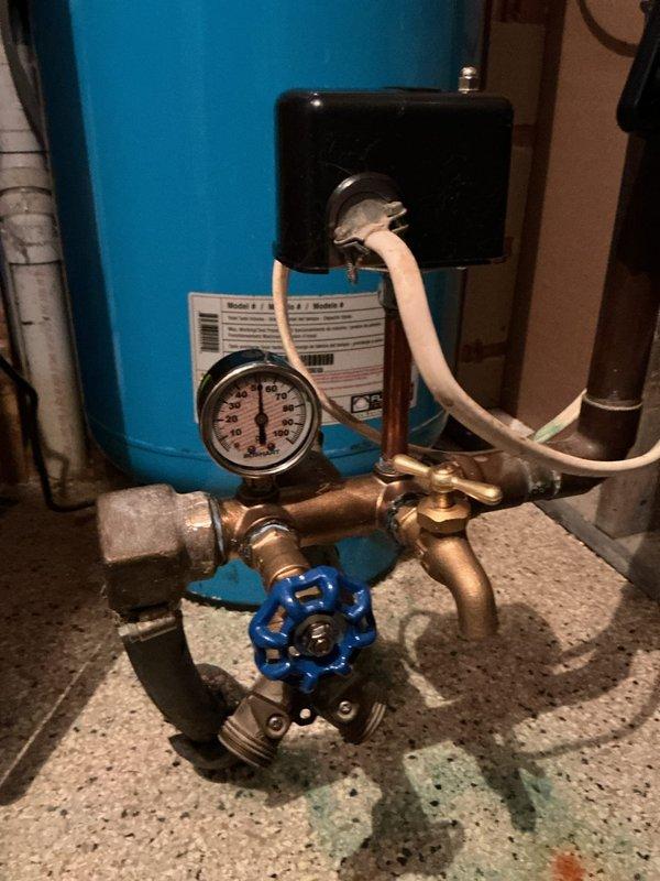 Replaced aging pressure tank assembly showing signs of corrosion and deterioration. Removed old components and installed complete new tank tee assembly including pressure switch, pressure gauge, sampling valve, and boiler drain. All brass fittings and connections secured to manufacturer specifications. System tested for proper pressure regulation and verified no leaks at connection points. New blue gate valve integrated into assembly for improved system control and maintenance access.