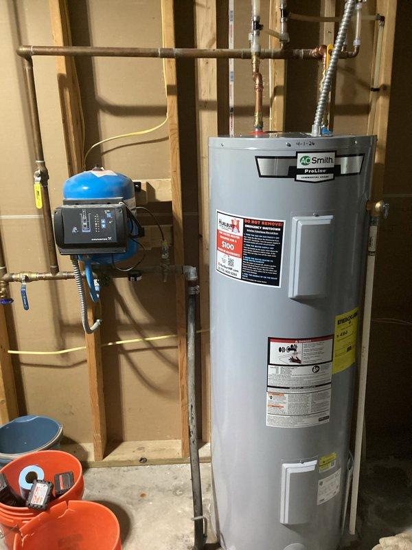 Responded to service call for leaking electric water heater with water discharge from bottom of unit. Removed failed water heater and installed replacement A.O. Smith electric water heater under parts warranty coverage. Completed full removal and replacement including all necessary connections to existing copper supply lines and electrical service, proper disposal of defective unit, and return of old water heater to shop with warranty documentation attached. Verified new installation for proper operation, tested all connections for leaks, and confirmed pressure tank and control system integration with new water heater. System restored to full operational status.