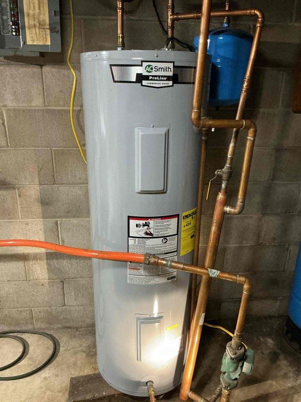 Responded to no hot water call on electric water heater. Customer was transitioning from wood boiler heating system back to electric water heater for seasonal operation. Found tripped high-temperature limit switch on unit. Reset the limit switch and restored hot water operation. Provided customer with verbal instructions on proper startup procedure for future seasonal conversions from wood boiler to electric water heater system.