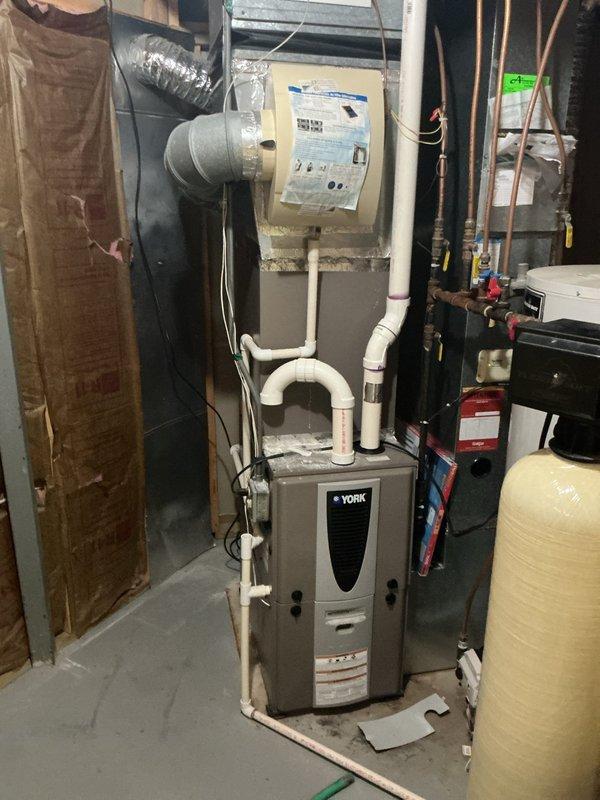 Successfully completed water heater replacement in basement utility room. Removed existing water heater unit and installed new tall white residential water heater with proper connections to overhead ductwork and copper supply lines. Installation included mounting control panel near top of unit, connecting all required plumbing fixtures, and ensuring proper integration with existing HVAC system, water softener, and filtration equipment. All manufacturer specifications and safety requirements were followed during installation, with documentation photos submitted for inspection approval.