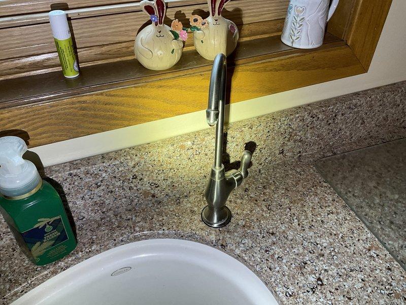 Responded to service call for leaking kitchen faucet and reverse osmosis faucet. Replaced worn Moen single-handle cartridge in main kitchen faucet to eliminate leak at base. Installed customer-supplied non-air gap reverse osmosis faucet on countertop. Tested both faucets for proper operation and verified all connections were secure with no leaks present.