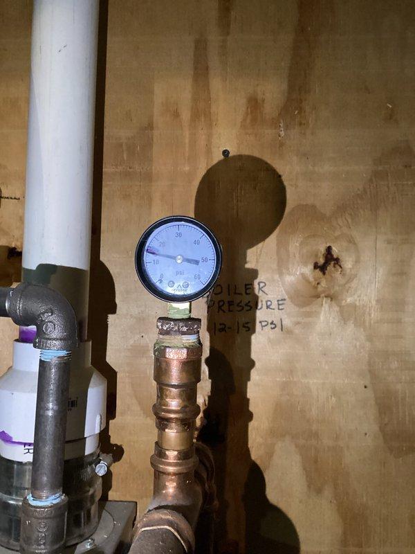 Replaced backflow preventer on hydronic heating system with exact bolt-on replacement unit. Removed existing backflow prevention device from copper piping assembly, installed new unit, and refilled system to proper operating pressure of approximately 50 PSI as indicated on boiler pressure gauge.