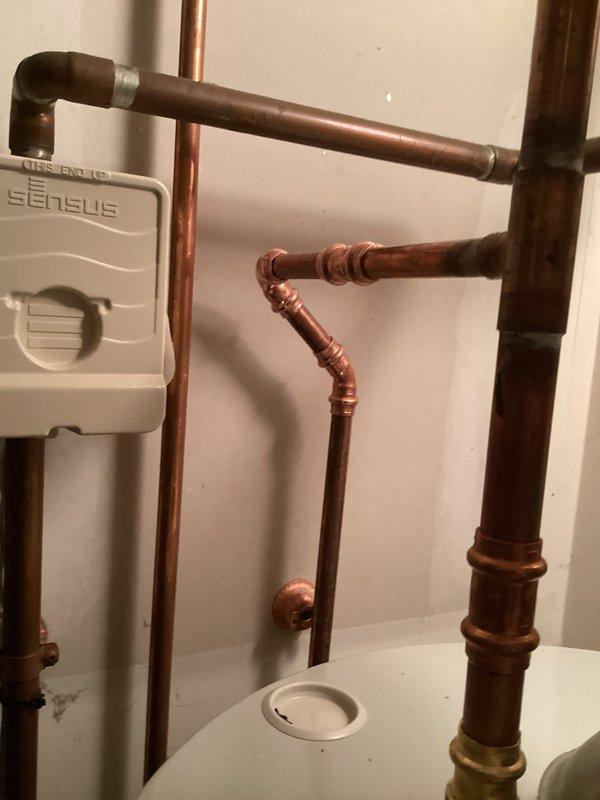 Repaired leak on 1/2" copper tubing located behind water heater by cutting out damaged section and installing new copper piping with proper compression fittings. Replaced deteriorated washing machine supply hoses on second floor laundry connection with new stainless steel braided hoses. Installed shock arrestors on hot and cold water lines serving washing machine to eliminate water hammer and protect plumbing system from pressure spikes. Replaced faulty water supply piping at washing machine connection point, ensuring all connections were properly secured and leak-free. All repairs tested under full pressure and verified operational.