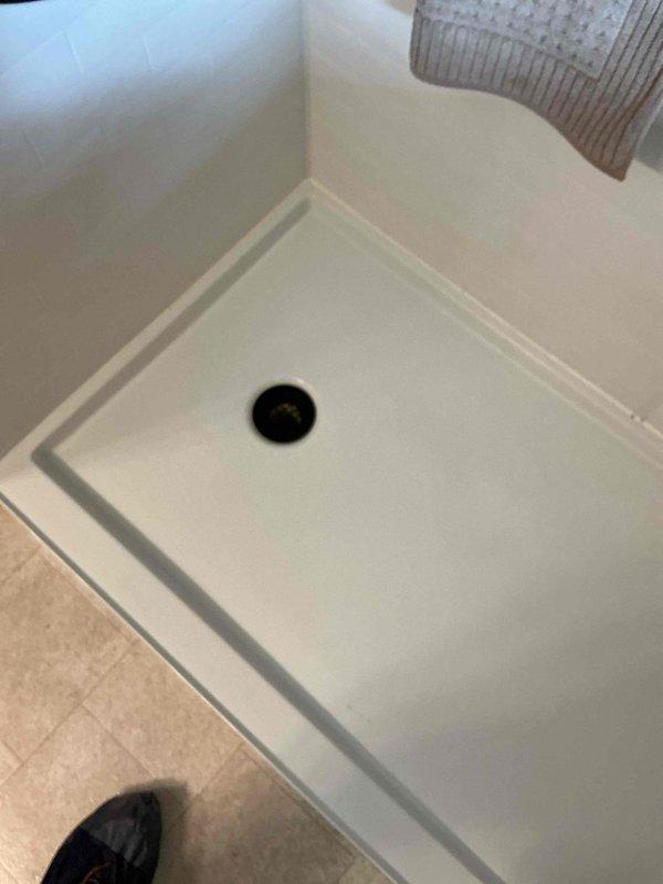Responded to a clogged shower drain in a walk-in shower that was recently converted from a tub installation. Upon inspection, identified a solid obstruction lodged in the 2-inch P-trap located close to the drain opening. Attempted to clear the blockage using standard augering techniques and a blow bag, but the obstruction proved too solid to dislodge with conventional methods. The blockage appears to be a hard foreign object rather than typical organic debris, and its location in the P-trap prevents passage of clearing equipment. Documented the condition with photographs and advised that the issue may be related to the recent shower remodel and recommended contacting the installing contractor to address the obstruction, as it may require trap removal or replacement to resolve.