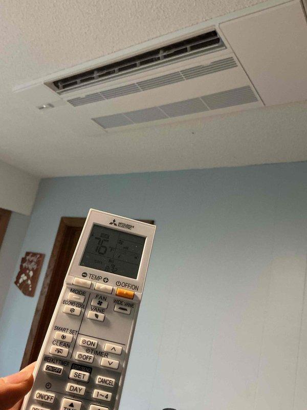 Responded to service call for newly installed Mitsubishi Electric mini-split system in upstairs bedroom with non-responsive vane and fan controls on remote. Diagnosed faulty remote control unit unable to communicate directional vane commands while heating function remained operational. Ordered replacement OEM Mitsubishi Electric remote control to restore full functionality of ceiling-mounted indoor unit including airflow direction and fan speed settings.
